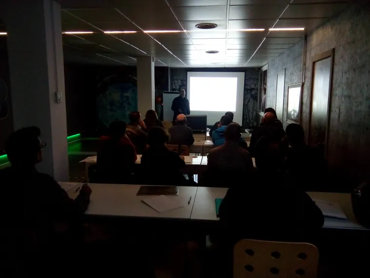 IMG_20171107_111309-3-1 Asistentes a una sesión formativa de Asselum en una sala a oscuras con proyección
